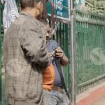 A man checking belts on a street - Log, Colour and B&W