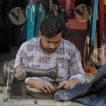 Man on a Sewing Machine in front a shop - Log, Colour and B&W