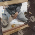 Worker putting nails on wood - log, colour and B&W