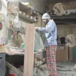 Carpenter working on plywood wide shot - log, colour and B&W