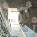 Carpenter tapping shelf wide shot - log, colour and B&W