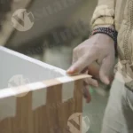 Man gluing on shelf close shot - log, colour and B&W