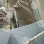 Man applying glue to shelf - log, colour and B&W