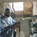 Man fixing plywood and applying tape - log, colour and B&W