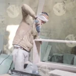 Carpenter using a power drill to assemble wooden pieces - Log, colour and B&W