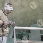 Man putting nails on plywood wide shot - log, colour and B&w