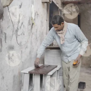 The man is continuously carving a figure on wood - Log, colour and B&W