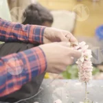 Worker stringing Garden Rose on thread - Log, colour and B&W