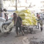 People using a handcart in a busy market area, in Chandni Chowk, - Log, colour and B&W