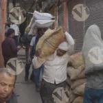 Carrying sacks of goods in a busy, narrow street - Log, colour and B&W
