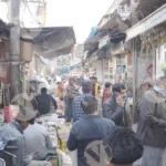 A market, filled with people and shop - Log, colour and B&W