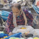 Man sorting through flowers - Log colour and B&W