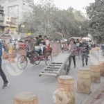 Street scene in Old Delhi, India, with cycle rickshaws and Man with handcart - Log, colour and B&W
