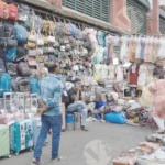 A Street Vendor Displaying a variety of Bags, Purses, and Luggage for Sale - Log, colour and B&W