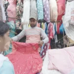 A Vendor Displaying Clothes to Customer - Log, colour and B&W