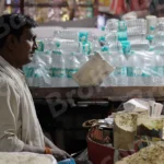 A Man Using a Balance Scale to Weigh Goods in a Market - Log, colour and B&W