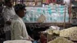 A Man Using a Balance Scale to Weigh Goods in a Market - Log, colour and B&W