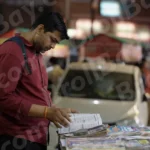 Man Reading Books in a Book Stall - Log, colour and B&W
