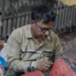Man Fixing Trolley Bag - Log, colour and B&W