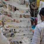 Man Selling Earrings in a Market - Log, colour and B&W